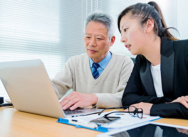 istock Asian business colleagues working on laptop 469577542