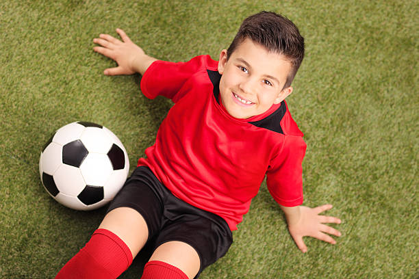 istock Junior soccer player sitting on a green field 469584010