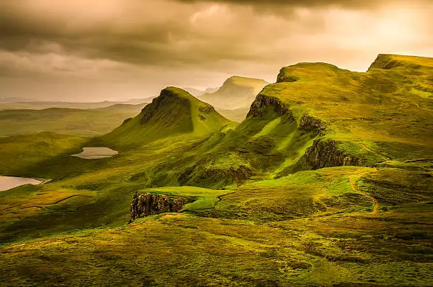 Scenic view of Quiraing mountains sunset with dramatic sky in Scottish highlands, Isle of Skye, United Kingdom