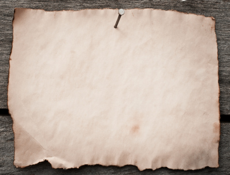 Old paper nailed to a grunge wooden background
