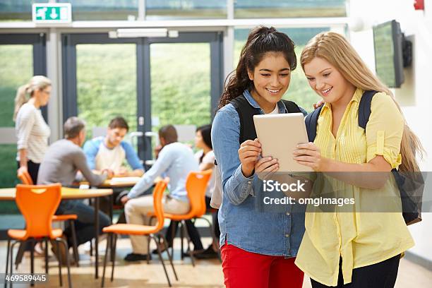 Two Female Teenage Students In Classroom With Digital Tablet Stock Photo - Download Image Now