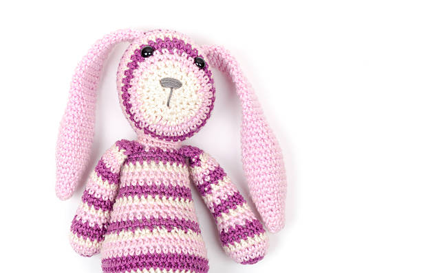 istock Funny knitted rabbit toy portrait over white wall 469591334