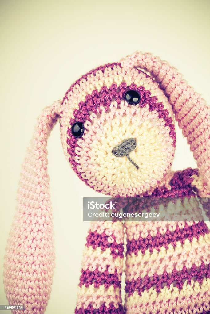 Funny knitted rabbit toy portrait, vintage toned Funny knitted rabbit toy portrait on white background, vintage toned photo with retro style toned effect 2015 Stock Photo