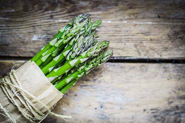istock Asparagus on rustic wooden background 469593029