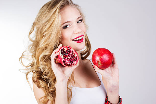 Portrait of young beautiful woman with pomegranates stock photo