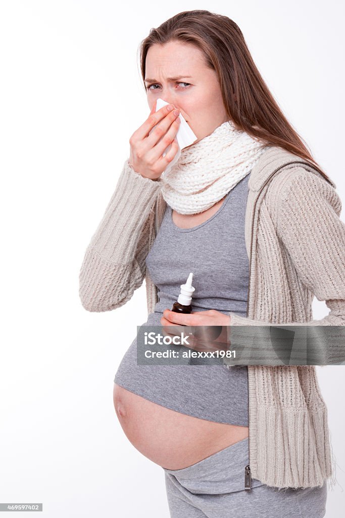 pregnant woman with handkerchief sneezes pregnant woman coughs and sneezes, uses nasal spray 2015 Stock Photo