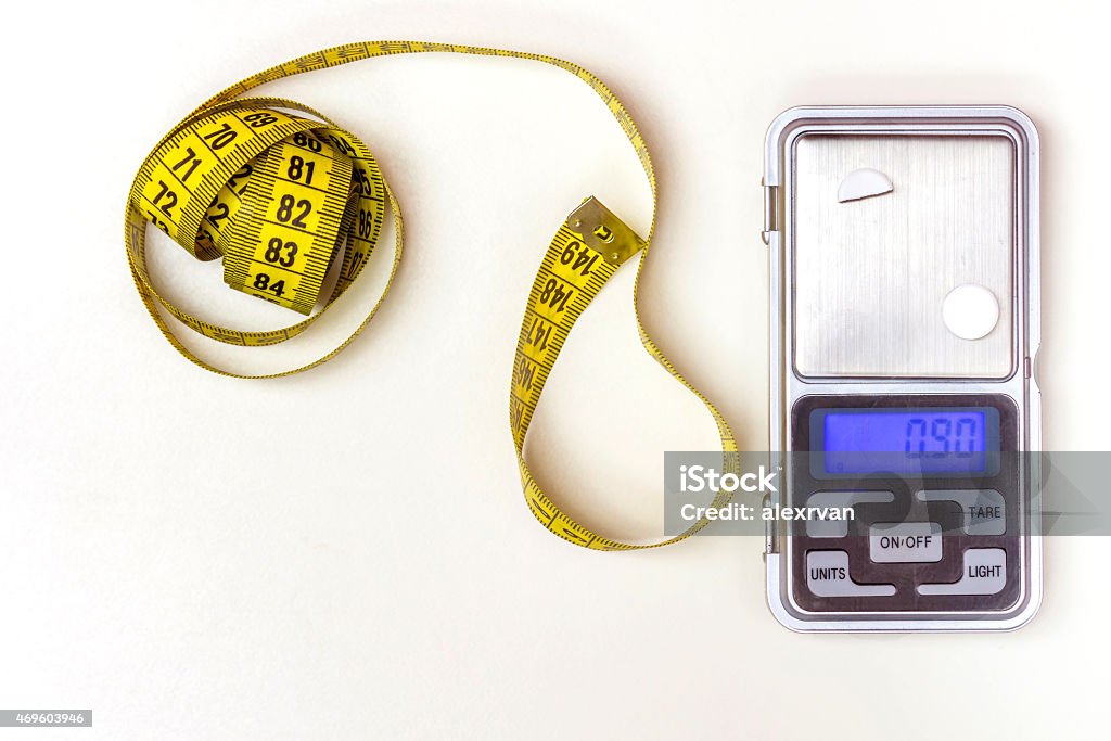 Measuring Tape and Medicine Scale Measuring Tape and a Medicine Scale on a white background 2015 Stock Photo