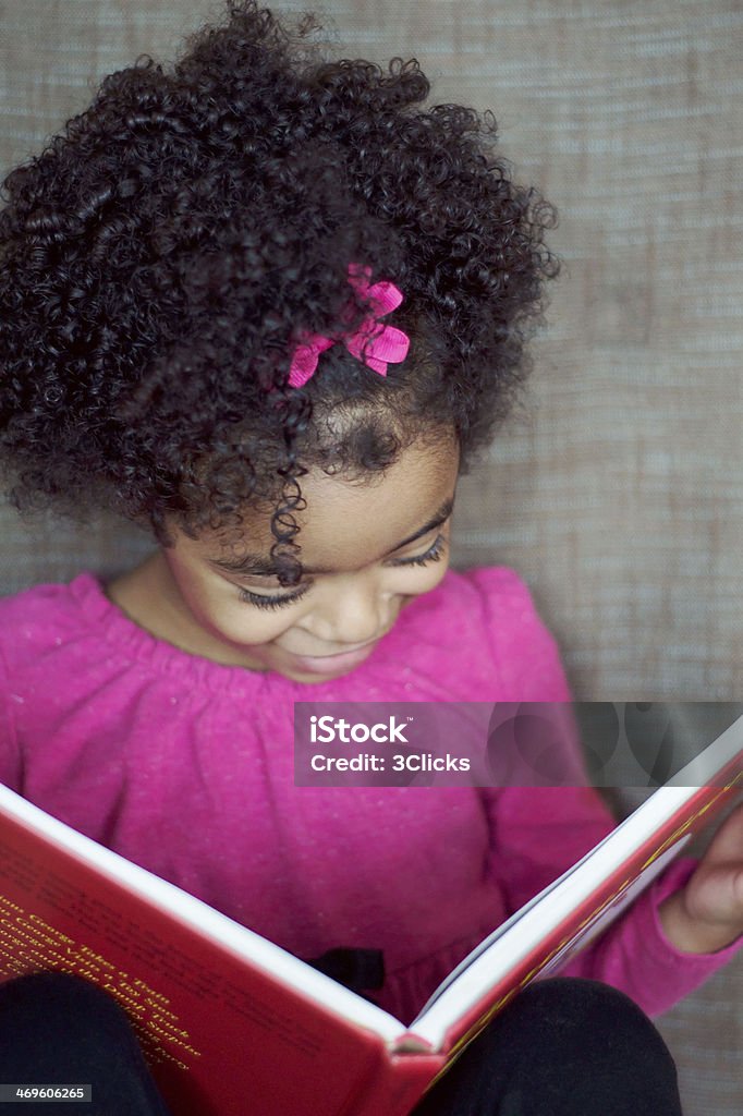 Preschooler Learning to Read Preschool aged, African American girl reading a book Reading Stock Photo