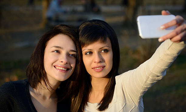 istock Two Beautiful Young Women Taking Photo Outside 469610667