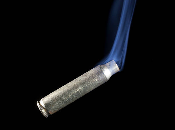 istock Smoking rifle cartridge on black 469614936