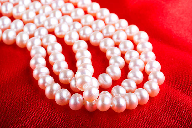 istock Pearl necklace on red silk 469616281