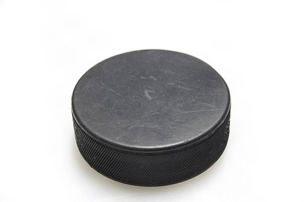 Black hockey puck in white background A hockey puck on a white background puck stock pictures, royalty-free photos & images