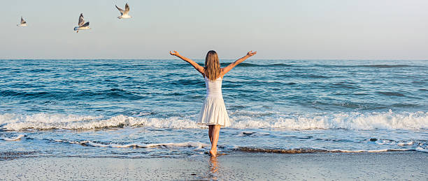 istock Girl standing at the beach 469617488
