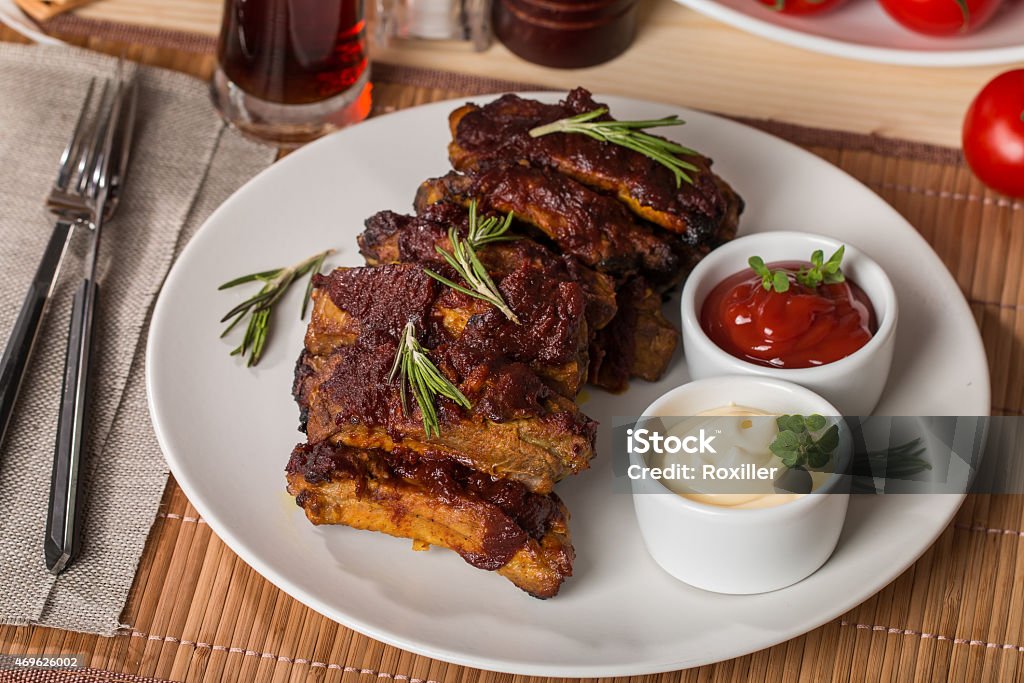 Grilled pork ribs in barbecue sauce Grilled pork ribs in barbecue sauce on white plate 2015 Stock Photo