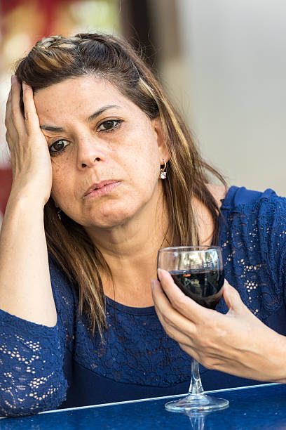 middle aged woman sad and drinking wine Mature woman very sad drinking wine, getting drunk alcoholism alcohol addiction drunk stock pictures, royalty-free photos & images
