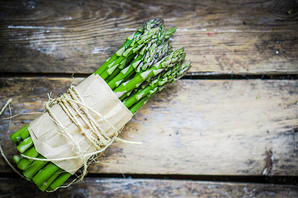 istock Asparagus on rustic wooden background 469630599