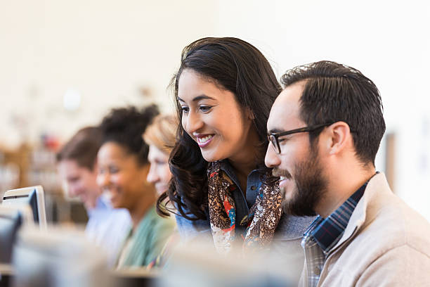 istock Hispanic adult college students studying together in computer lab 469637694