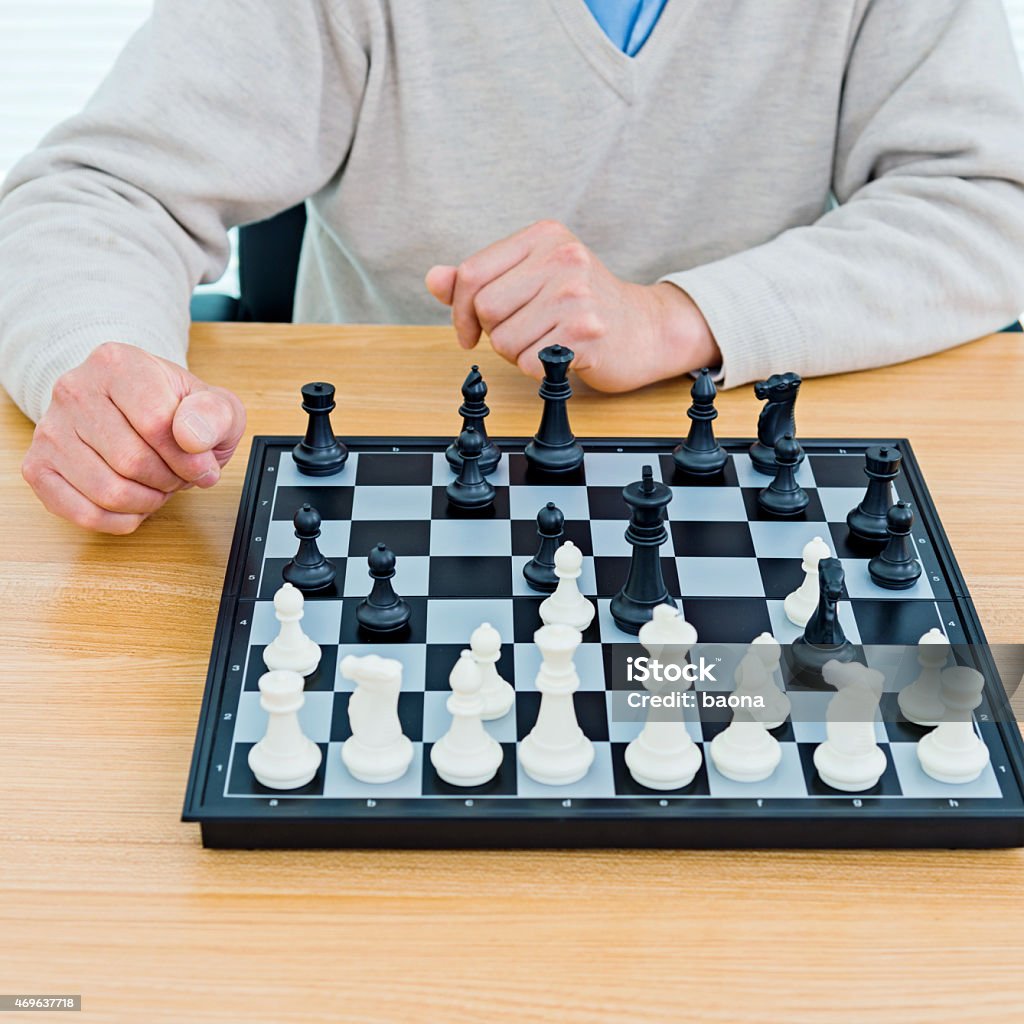 Senior man playing chess Asian senior man playing chess. 2015 Stock Photo