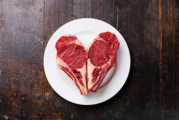 cuore a forma di carne cruda bistecca su piatto - meat raw beef love foto e immagini stock