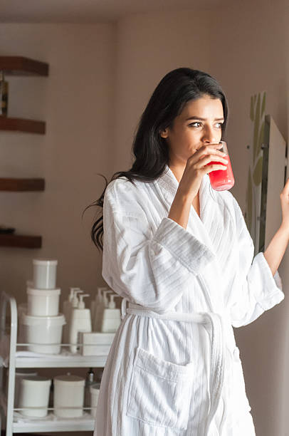 istock Middle Eastern Woman in Spa Treatment Room Drinking Juice 469640914