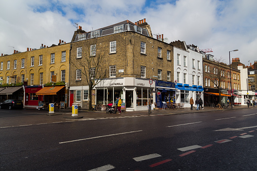 London, UK - March 26, 2015: A view of various restaurants and businesses along Upper Street in Islington, london. People can be seen.