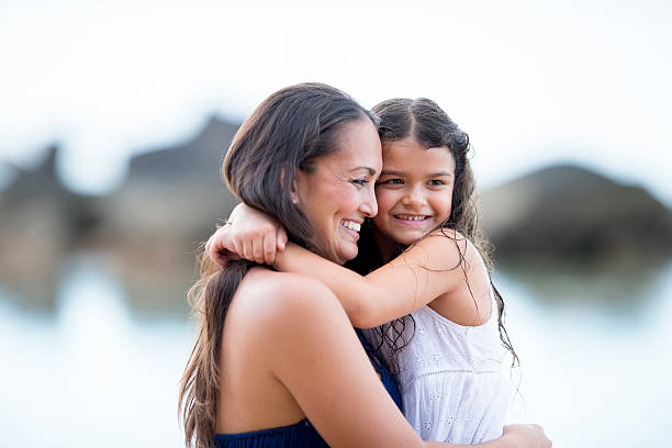 Mother and daughter bonding and spending quality time on a beach in Hawaii.
