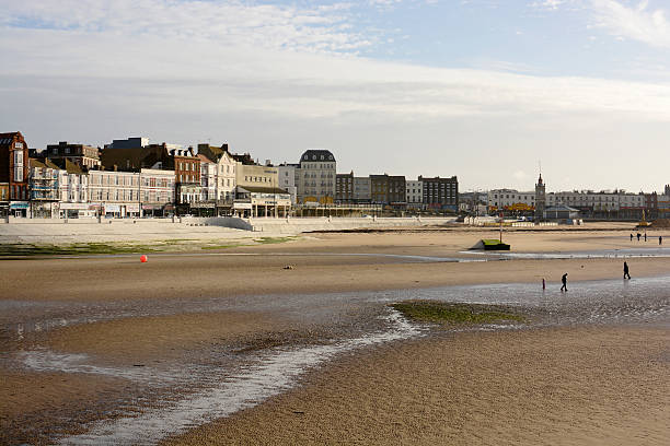 Margate seafront. Kent. England Canterbury, England - November 12, 2013: Margate town and seafront viewed from harbour wall. Kent. England. Low tide with people walking on beach isle of thanet photos stock pictures, royalty-free photos & images