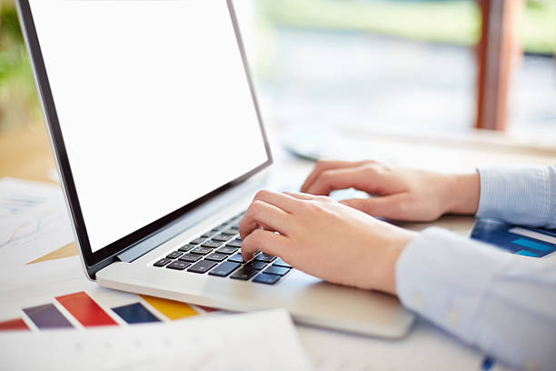 istock Businesswoman using laptop with blank screen at desk 469649458
