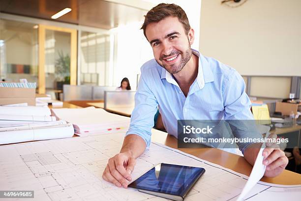 Male Architect With Digital Tablet Studying Plans In Office Stock Photo - Download Image Now