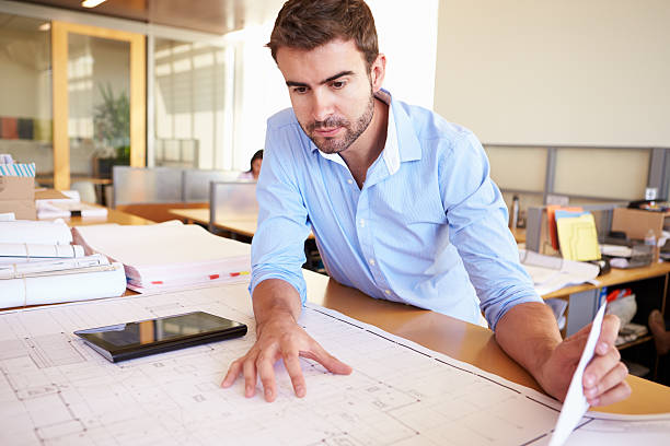 istock Male Architect With Digital Tablet Studying Plans In Office 469649687