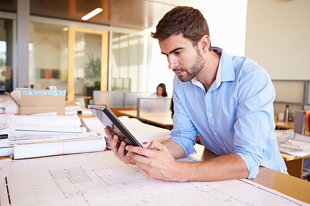 istock Male Architect With Digital Tablet Studying Plans In Office 469649699