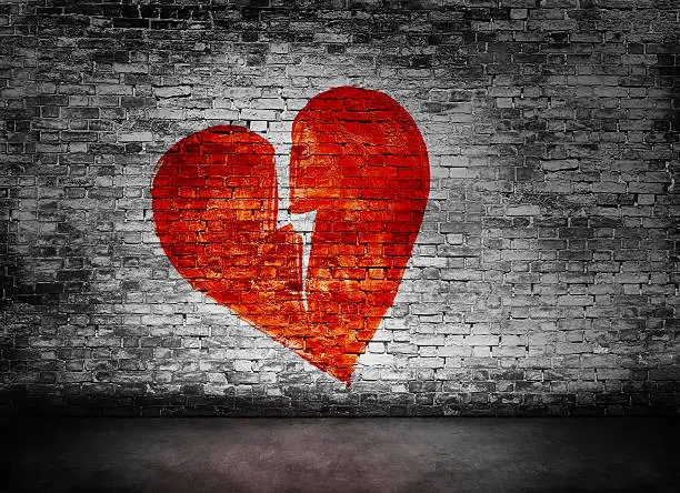 Shape of broken heart on murky brick wall