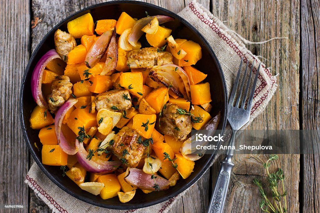 Top view of roasted pumpkin and meat in a pan on wood Roasted pumpkin and meat on the pan, top view 2015 Stock Photo