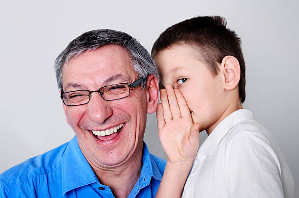 es muy divertido - whispering grandparent child grandfather fotografías e imágenes de stock