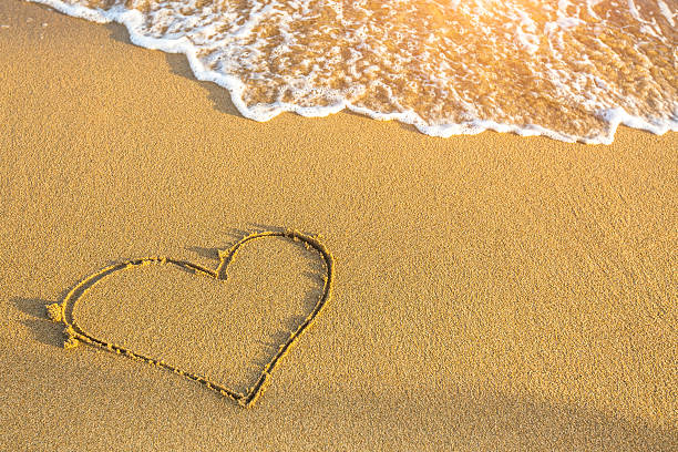 istock Heart drawn in sea beach sand. 469657578