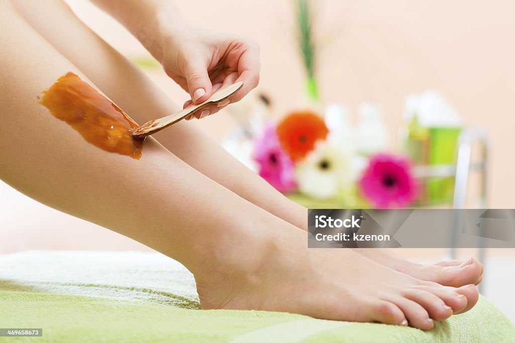 Woman in Spa getting leg waxed for hair removal Young woman in Spa getting legs waxed for hair removal Adult Stock Photo