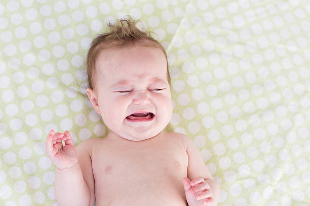 istock Little crying newborn baby on a green blanket 469660803