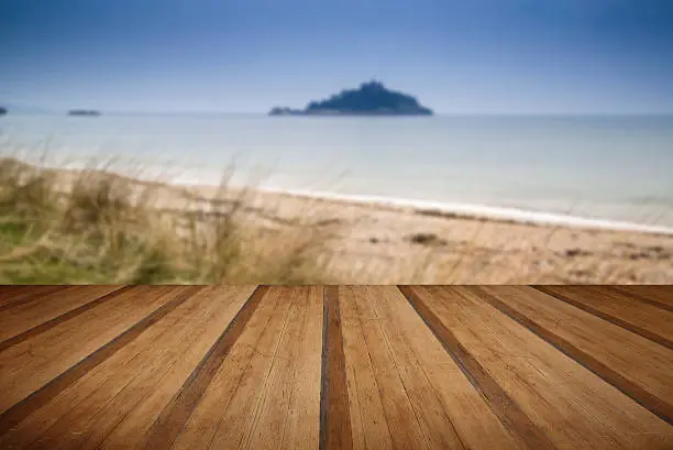 Island castle landscape viewed through sand dunes with wooden planks floor platform