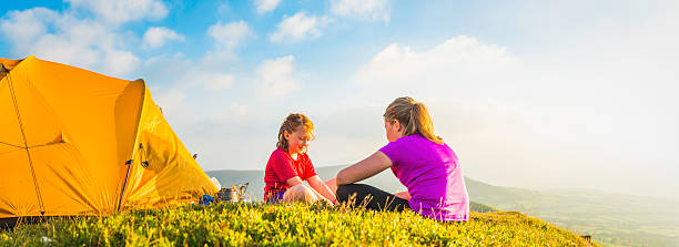 istock Kids wild camping on idyllic mountain top summer sunset panorama 469663890