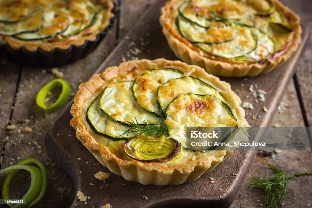 tart with zucchini, leek and cheese on rustic background Tart - Dessert Stock Photo