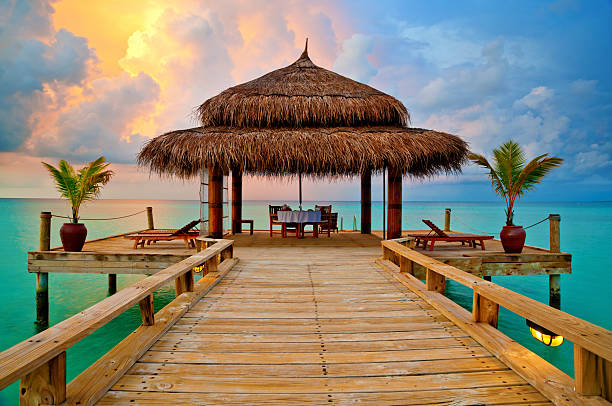 Tropical hut on water at sunset - romantic dinner in paradise