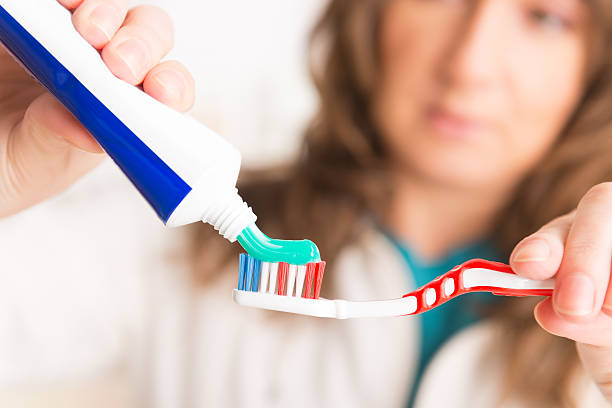 istock Woman holding toothbrush and toothpaste 469667769