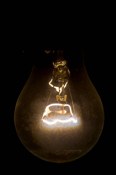 istock Old lamp with an incandescence thread on a black 469667824