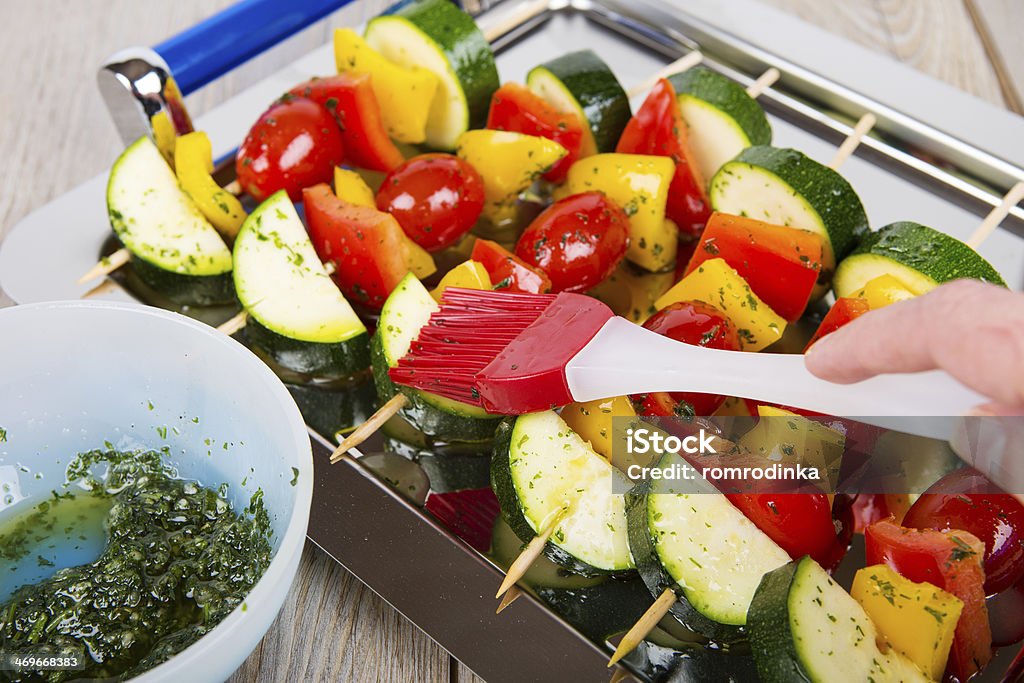 Vegetable skewers with tomato, pepper and zucchini Hand coating fresh prepared vegetable skewers with tomato, pepper and zucchini with herb dip Appetizer Stock Photo