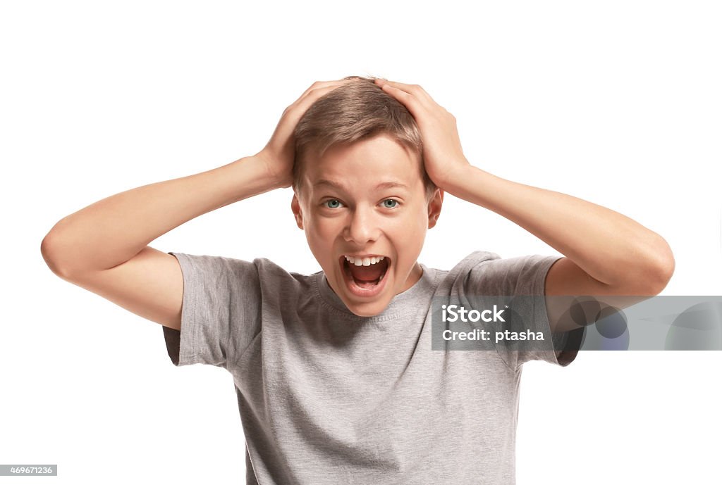 Amazed teenager holding his head Amazed teenage boy holding his head. Isolated on white background Surprise Stock Photo