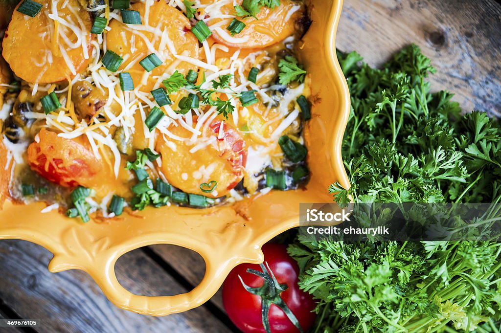 Baked vegetables in a dish on wooden background Baked Stock Photo
