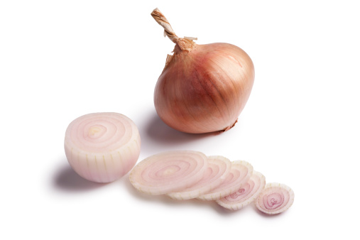 Pink Roscoff onions and slices on white background