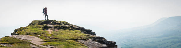 istock Female hiker looking at view from mountain summit panorama Wales 469682410