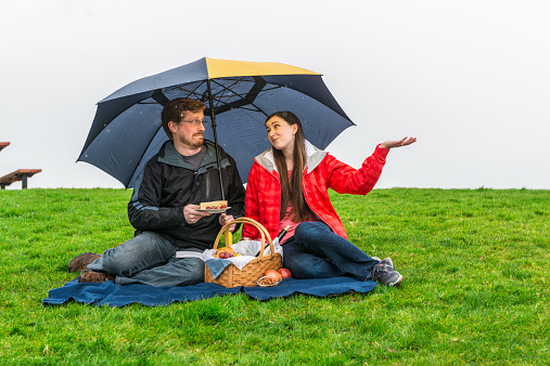 Young couple having a picnic in the rain