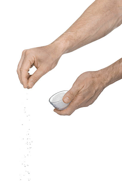 istock Tw male hands adding crushed salt on a white background 469683128